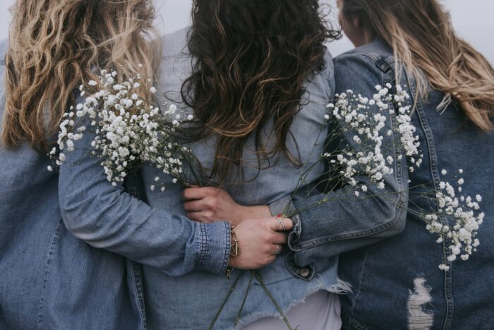 仲良しな３人の女性の後ろ姿の写真