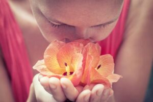 花の匂いを嗅ぐ女性の写真